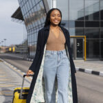full-shot-smiley-woman-walking-with-baggage.jpg